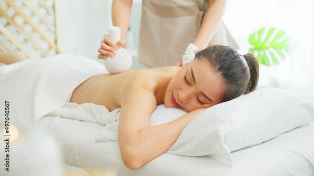 Asian beautiful woman enjoy thai hot compress massage with herbal bags Asian beautiful woman enjoy thai hot compress massage with herbal bags