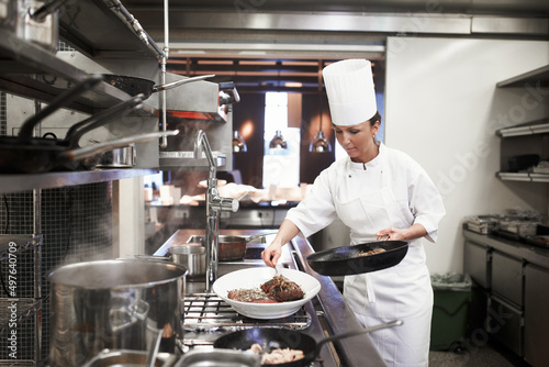Eating is necessary but cooking is an art. Shot of chefs preparing a meal service in a professional kitchen. photo