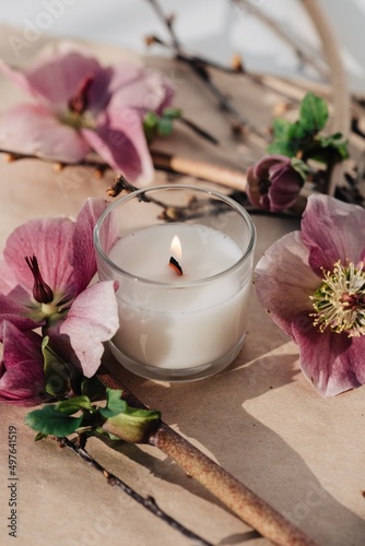 Burning aromatic candle and flowers photo