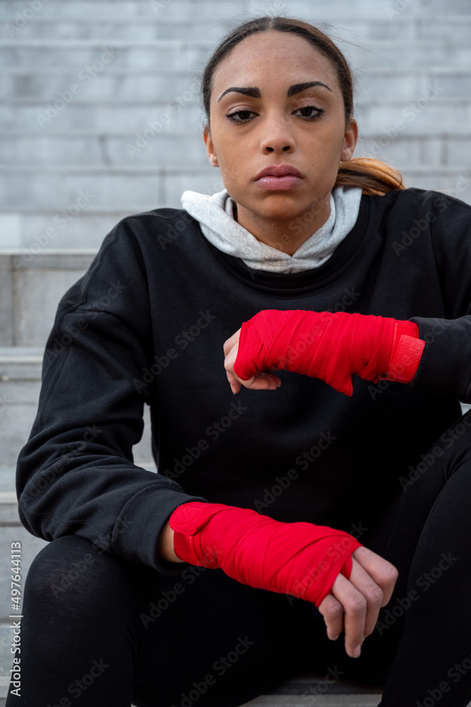 Self confident Hispanic fighter in bandages in city Self confident Hispanic fighter in bandages in city