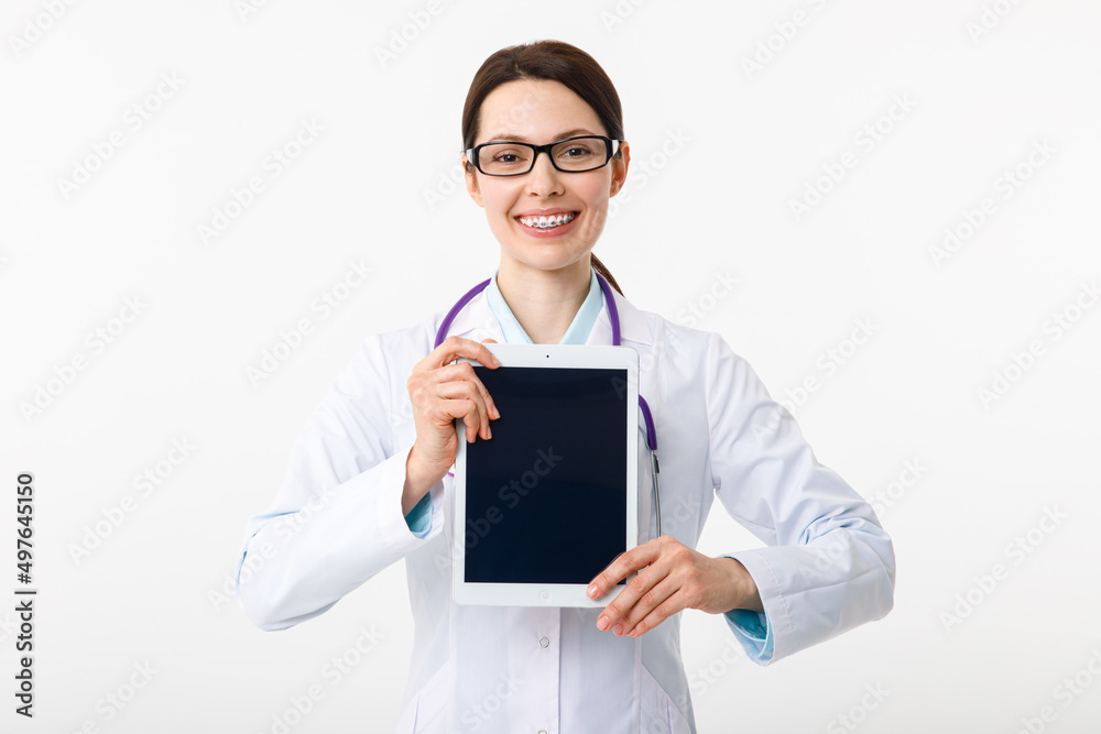 Cheerful young female doctor holding a clipboard in her hand and pointing to copyspace with a gesture Cheerful young female doctor holding a clipboard in her hand and pointing to copyspace with a gesture
