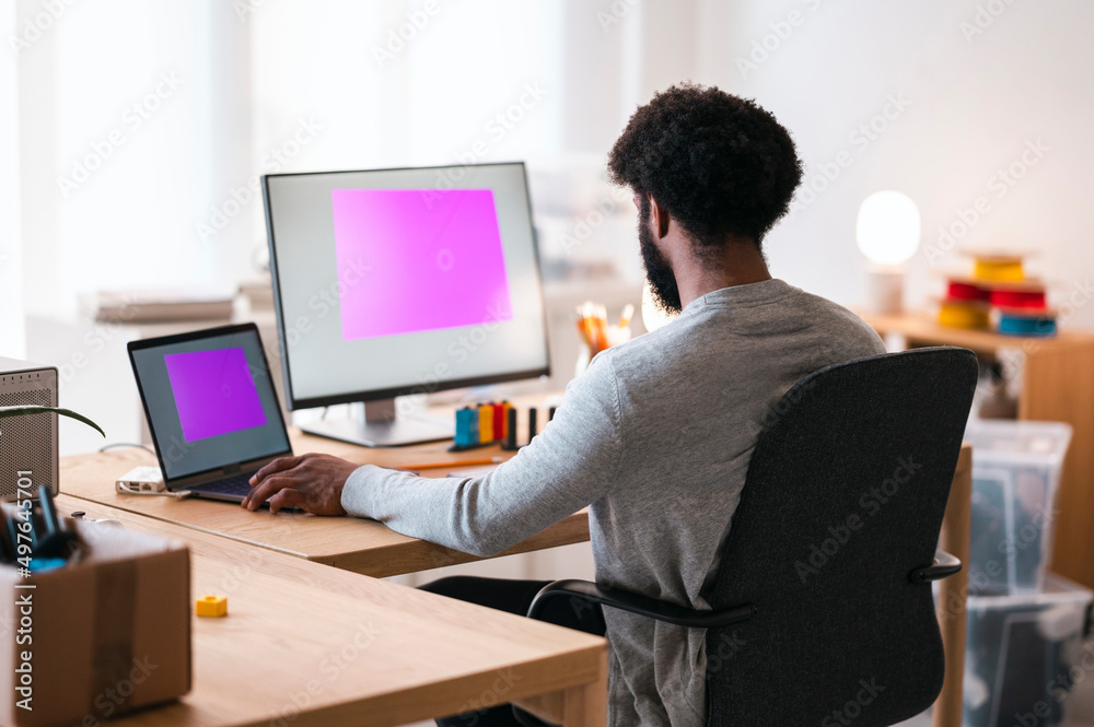 Male designer creating 3D illustration on PC and laptop Male designer creating 3D illustration on PC and laptop