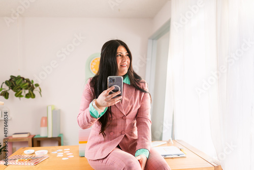 Trendy businesswoman working with phone in office