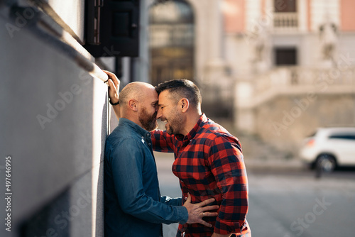 Loving couple of homosexual men embracing in city photo