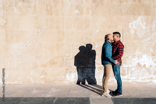 Gay couple in love kissing in city photo