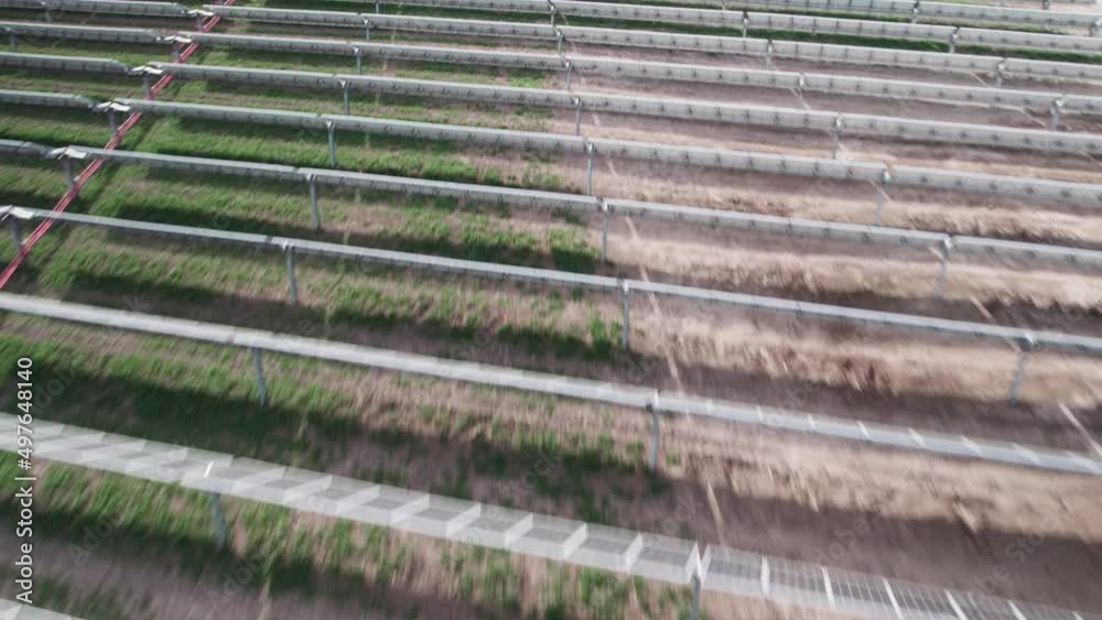 Flying fast and low over horizontal rows of solar photovoltaic panels at a green energy facility Flying fast and low over horizontal rows of solar photovoltaic panels at a green energy facility
