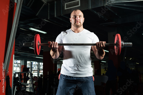 Male athlete lifts the barbell