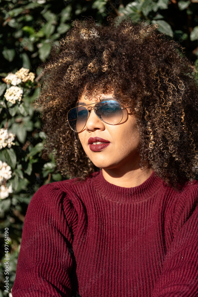 Peaceful curly haired woman in glasses in park Peaceful curly haired woman in glasses in park