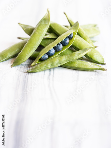 Peapods revealing blueberries inside
