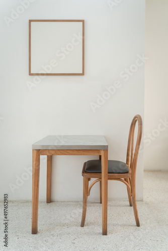 Classic set of wooden chairs and table with wooden blank space photo frame interior on the white marble floor for modern house and decoration living room.