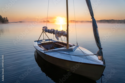 Dinghy Sailboat on Misty Lake At Sunrise photo