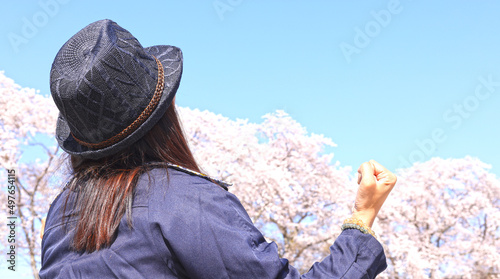 桜とガッツポーズの女性