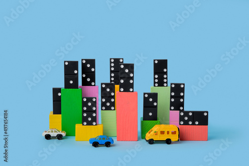 Сolored cubes with domino over it and toy cars near photo