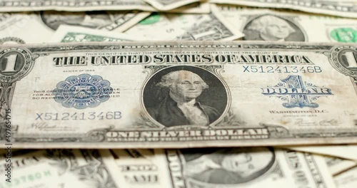 Historic Silver Certificate Dollar banknote on top of new 1 Dollar bills. United States of America currency Inflation