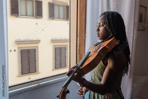 Black girl with viola by an open window photo