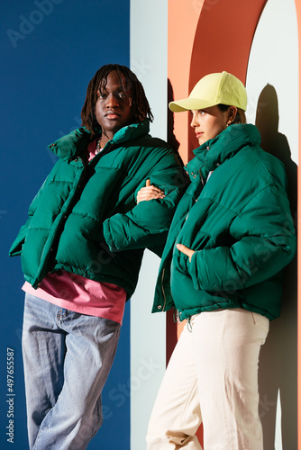 Trendy diverse couple in outerwear near arch