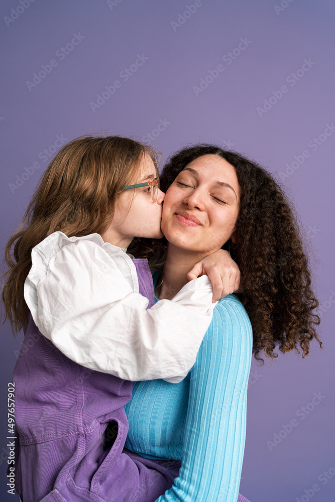 Charming sisters in trendy clothes embracing in studio Charming sisters in trendy clothes embracing in studio