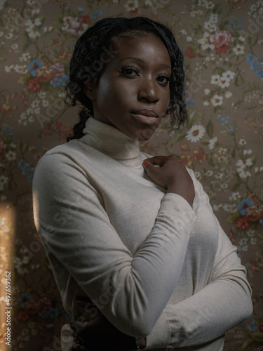 Dark portrait of a girl on a background of floral wallpaper photo