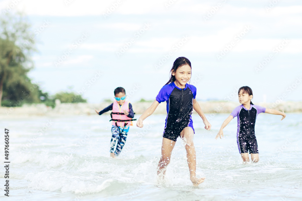 little Asian boy and girl running and playing with smiling and laughing on tropical beach at sunset. Portrait of Adorable young child kids having fun in summer holiday vacation travel. little Asian boy and girl running and playing with smiling and laughing on tropical beach at sunset. Portrait of Adorable young child kids having fun in summer holiday vacation travel.