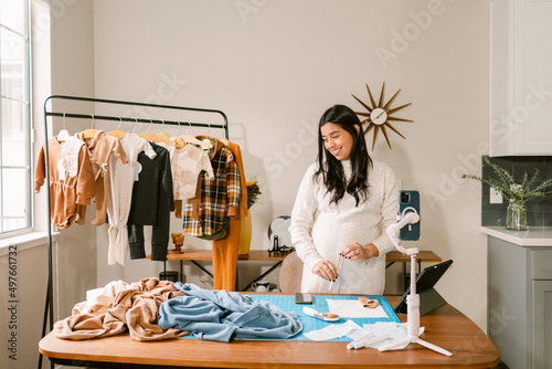 Pregnant dressmaker working in home atelier photo