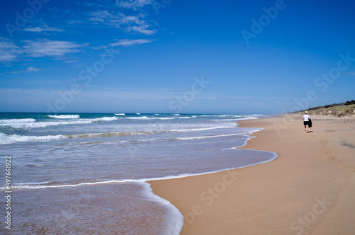 Woman walking on beautiful 90 Mile Beach