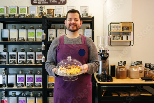 Happy enterpreneur with desserts in eco friendly shop photo