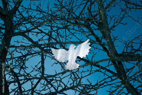 Figurine of a dove in dry branches photo