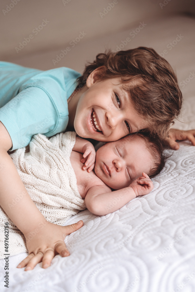 Portrait of a young boy snuggling with his baby sister Portrait of a young boy snuggling with his baby sister