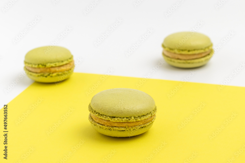 Pistachio Macarons on yellow background close up. Pistachio Macarons on yellow background close up.