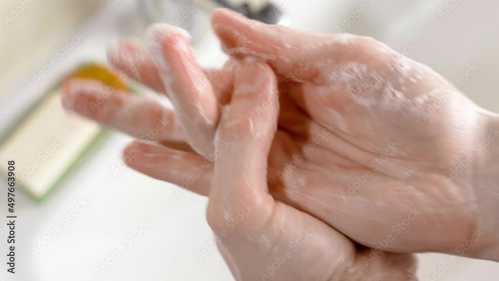 Thorough washing of hands with soap close-up on the background of the sink in the bathroom Thorough washing of hands with soap close-up on the background of the sink in the bathroom
