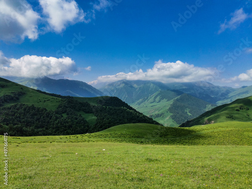 The landscape of the green Aktoprak pass in the Caucasus, the road and the mountains under gray clouds. Russia.