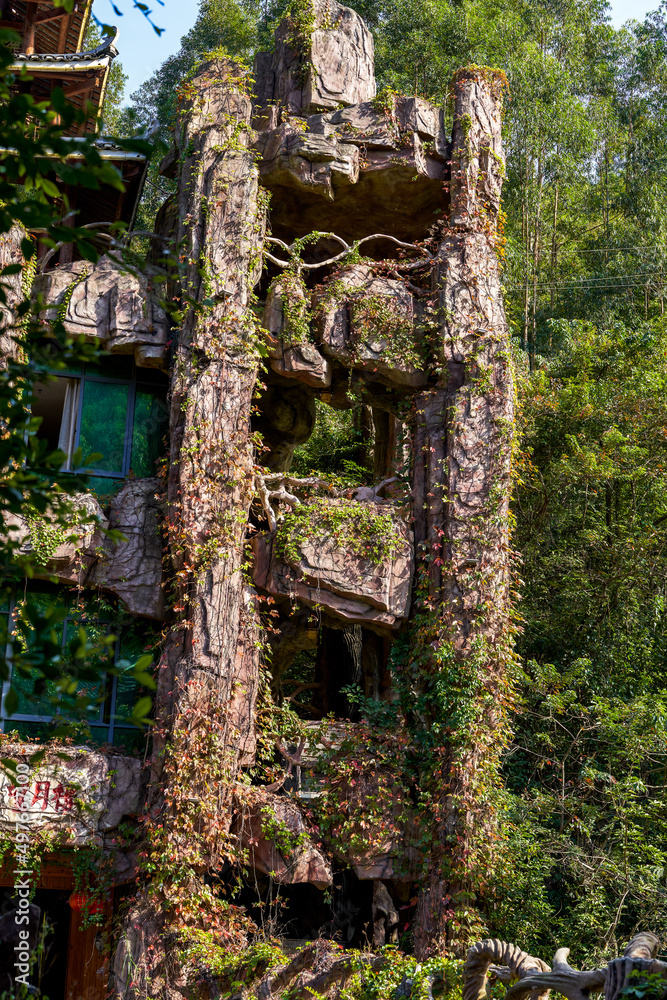 Creepers-covered building made of rockery stone in an outdoor park Creepers-covered building made of rockery stone in an outdoor park