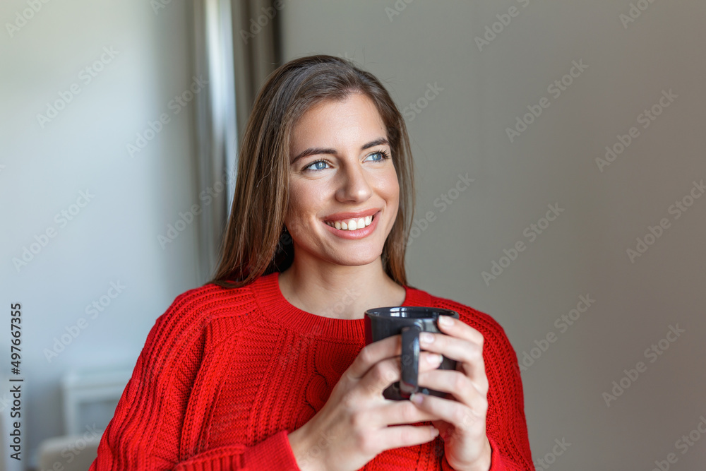 Closeup view of young woman with cup of hot drink at home, blank space. People, drinks and leisure concept - happy young woman with cup of tea or coffee at home Closeup view of young woman with cup of hot drink at home, blank space. People, drinks and leisure concept - happy young woman with cup of tea or coffee at home