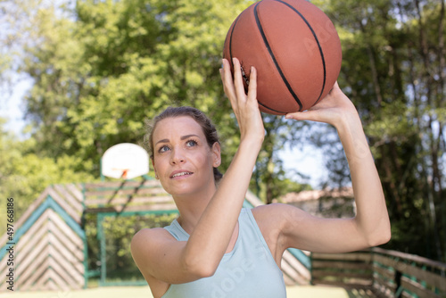 young woman ready to throw basketball into loop