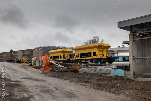 Construction site of a train station of Grosuplje, that is being renovated. Cold spring day with clouds, visible yellow gravel waggons.