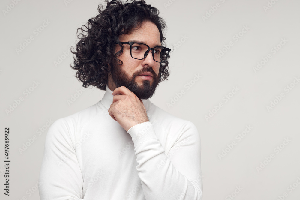 Pensive bearded man in eyeglasses touching chin in studio Pensive bearded man in eyeglasses touching chin in studio