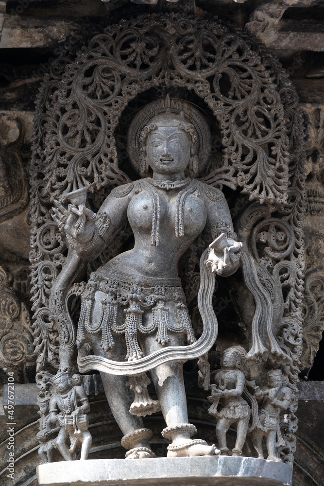 Stone Sculpture of Beautiful Female (Madanikas) with selective focus, 12th century Hindu temple, Ancient stone art and sculptures in each pillars, Chennakeshava Temple, Belur, Karnataka, India.