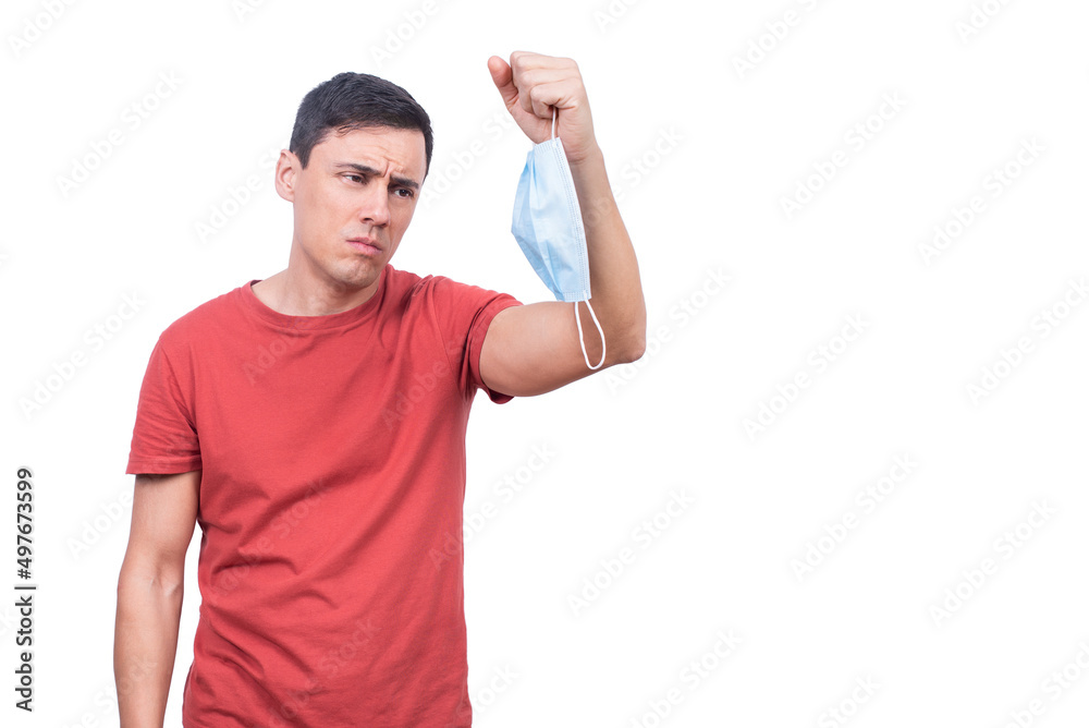 Tired man looking at medical mask during COVID pandemic Tired man looking at medical mask during COVID pandemic