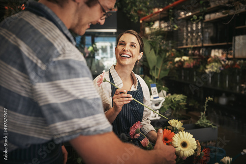 Flowers brighten up any day. Cropped shot of two young florists working together inside their plant nursery.