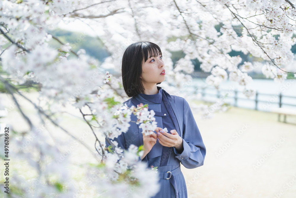 桜満開の中を散策する女性