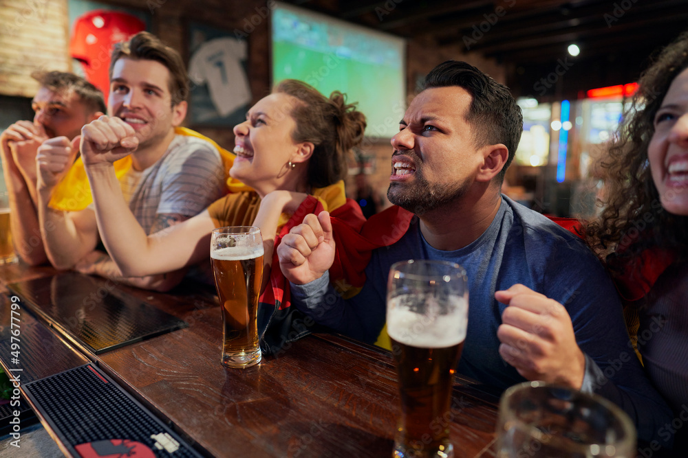 Cheering friends of soccer fans in the pub Cheering friends of soccer fans in the pub