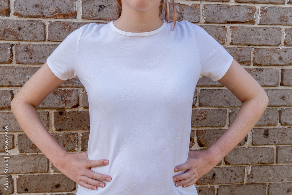 Girl wearing mockup white t-shirt on brick wall background. Template copy space Girl wearing mockup white t-shirt on brick wall background. Template copy space