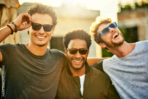 Killing it in the shades game. Shot of a group of young men hanging out together outdoors.