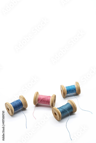 Colorful threads for sewing. Different threads on wooden vintage reels.