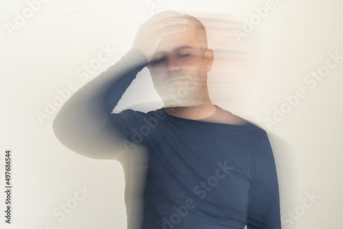 Close up photo of man with vertigo ilness. Motion blur effect intentionally applied. Dizziness and tension and medicine side effect concept.