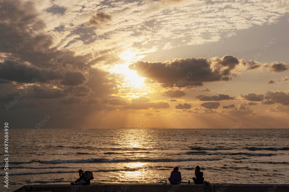 沖縄　北谷　宮城海岸で夕日を見る人々