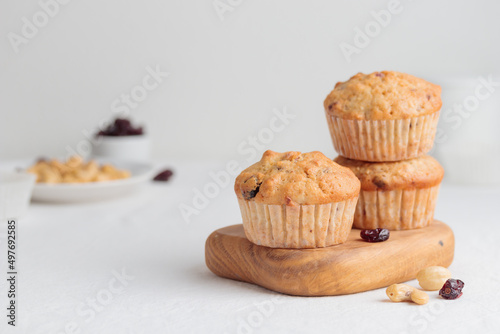 Muffins in a wooden plate on a white table