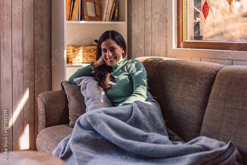 Foto Portrait of a brunette woman, smiling at the camera, covered with a blanket