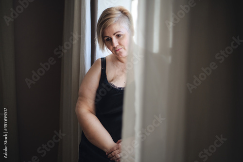 Depressed lonely fat woman in underwear looking down and thinking at home.