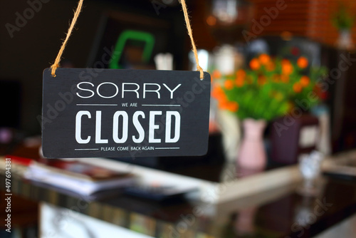 "Sorry we are closed" message board placed and please come back again on a glass door.